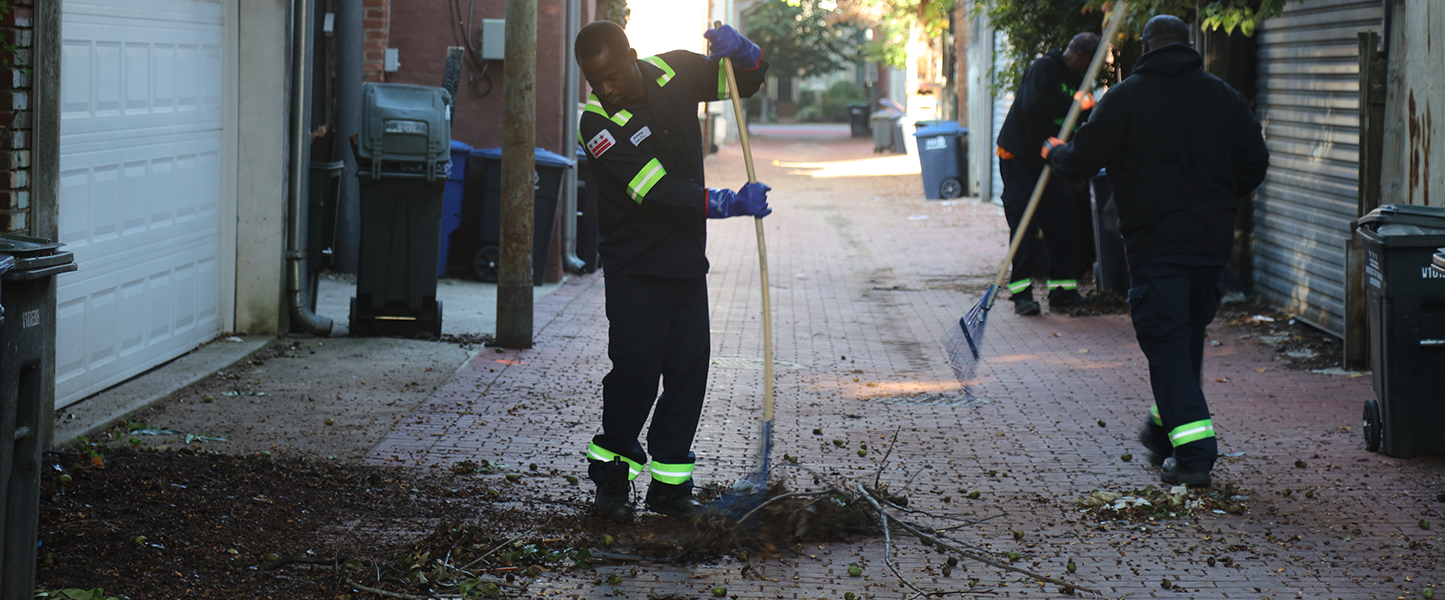 Image of sanitation worker cleaning alley